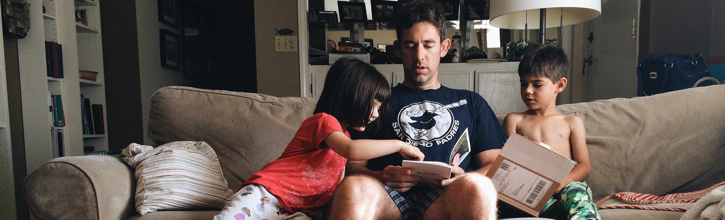 foto - Man leest brochures in zetel met kinderen